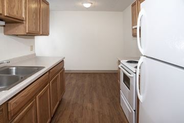 Hopkins apartment for rent - the preserve at ballantyne commons apartment kitchen with white appliances and wooden cabinets