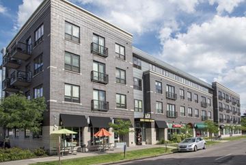 Minneapolis apartment for rent - a large apartment building on a city street with a car