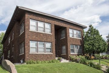 Minneapolis apartment for rent - the front of a brick apartment building with a lawn and steps