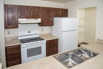Minneapolis apartment for rent - a kitchen with white appliances and wooden cabinets