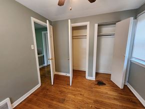 Munster house for rent - a bedroom with four closet doors and a wood floor