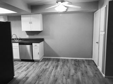 Chandler apartment for rent - A kitchen with a black fridge, white cabinets, and a ceiling fan.