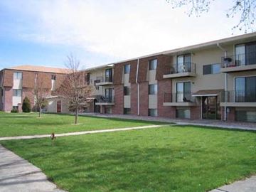 Kearney apartment for rent - an apartment building with a dog walking in the grass