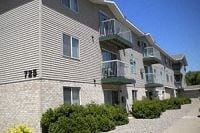 Hutchinson apartment for rent - Apartment building with balconies and bushes in front.