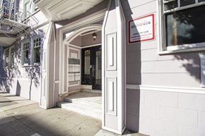 San Francisco apartment for rent - A white building with a black door and a sign that says "RETAIN".