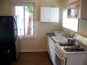 Santa Barbara apartment for rent - A kitchen with a black fridge and white cabinets.