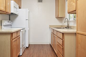 Mountain View apartment for rent - A kitchen with wooden cabinets and a white refrigerator.