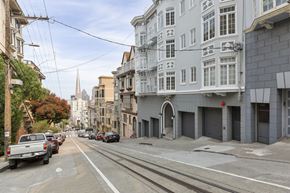 San Francisco apartment for rent - A street view of a city with buildings on both sides and cars parked on the side of the road.