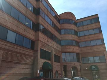 Newton apartment for rent - A large brown building with a green awning and a sign that says "The Lounge".