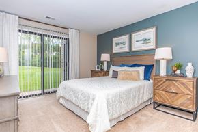 Farmington Hills apartment for rent - a bedroom with a bed and a sliding glass door