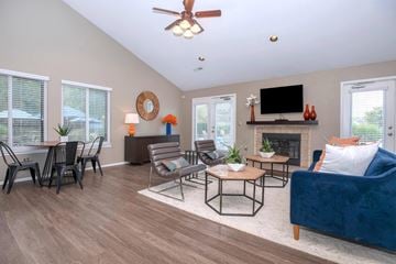 Farmington Hills apartment for rent - a living room with a blue couch and a table with chairs