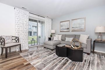 Rochester Hills apartment for rent - a living room with a gray couch and a sliding glass door