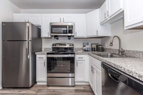 Rochester Hills apartment for rent - a kitchen with stainless steel appliances and white cabinets