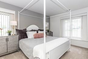 Rochester Hills apartment for rent - a bedroom with a white bed and a mirrored closet