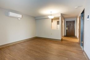 Utica apartment for rent - an empty living room with a wood floor and white walls