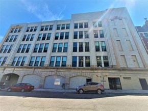 Utica apartment for rent - a large building with cars parked in front of it