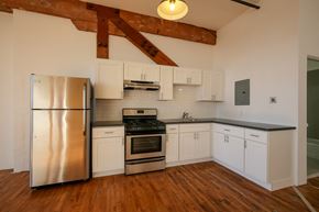 Oakland apartment for rent - A kitchen with a stainless steel refrigerator and wooden floors.