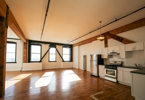 Oakland apartment for rent - A large open space with wooden floors and white walls.