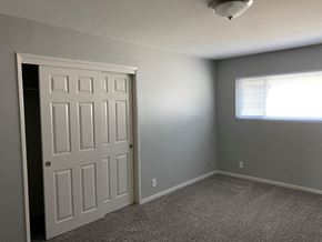 Bakersfield apartment for rent - a bedroom with a door and a window and a carpeted floor