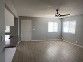 Bakersfield apartment for rent - an empty living room with a ceiling fan and a door