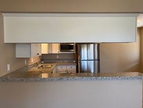Bakersfield apartment for rent - a kitchen with a granite counter top and a stainless steel refrigerator