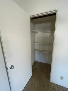 Mesa apartment for rent - A white door with a silver handle is open to a room with a white wall and a tiled floor.