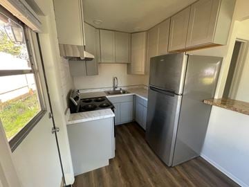 Mesa apartment for rent - a small kitchen with white cabinets and a stainless steel refrigerator
