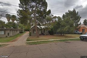 Mesa apartment for rent - A street view of a residential area with houses and trees.