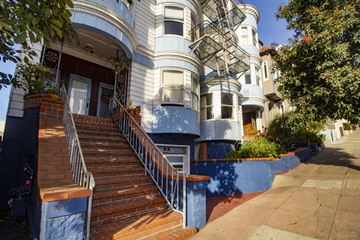 San Francisco apartment for rent - A blue and white building with a staircase leading to the front door.