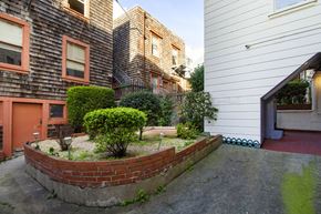 San Francisco apartment for rent - A small garden with a hedge and a brick wall.
