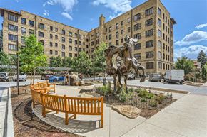 Denver apartment for rent - A statue of a horse is in the middle of a courtyard with benches around it.