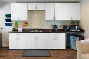 Hudson apartment for rent - A kitchen with white cabinets and a black countertop.