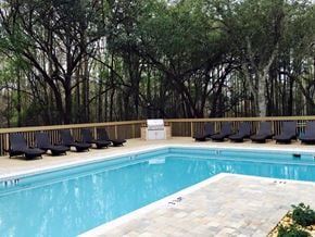 Hudson apartment for rent - A pool surrounded by trees and lounge chairs.