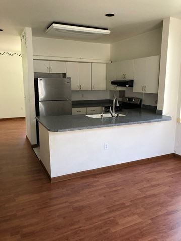 Kapolei house for rent - A kitchen with a stainless steel refrigerator and wooden floors.