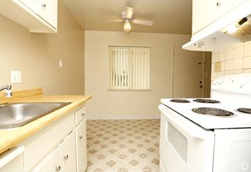 Hayward apartment for rent - A kitchen with a white stove top oven and a white tiled floor.