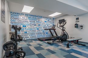 Pittsburgh townhouse for rent - a gym with weights and a wall with words on it