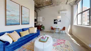 Albany apartment for rent - a living room with a blue couch and a white table