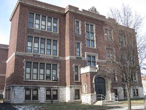 Troy apartment for rent - a large brick building with a tree in front of it