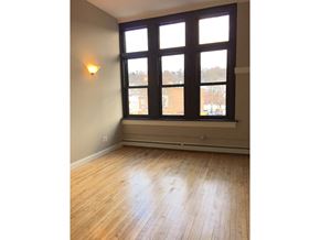 Troy apartment for rent - an empty living room with large windows and wood floors