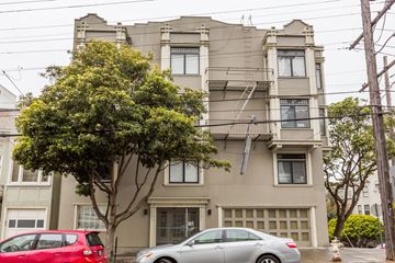 San Francisco apartment for rent - A grey two-story building with a tree in front of it.