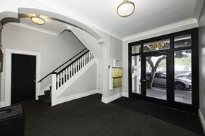 San Francisco apartment for rent - A black and white hallway with a staircase and a glass door.
