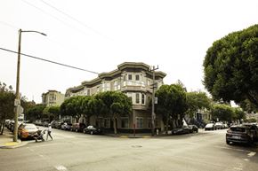 San Francisco apartment for rent - A street view of a building with cars parked in front.