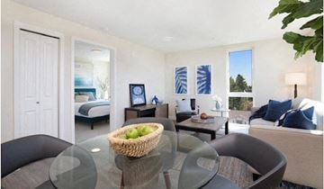 Shoreline apartment for rent - A living room with a glass table and a woven basket on it.