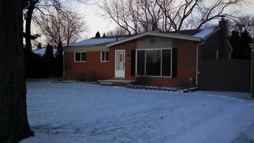 Waterford Township house for rent - A house with a white door and windows is surrounded by snow.