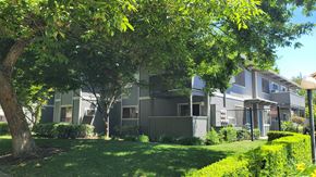 Modesto apartment for rent - an apartment building with green grass and trees