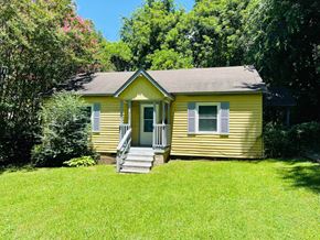 Jonesboro house for rent - A yellow house with a porch and a green lawn.