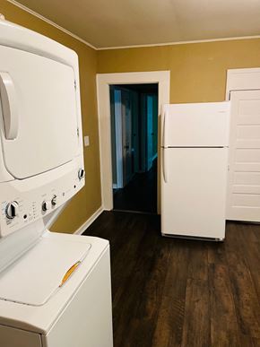 Jonesboro house for rent - A white oven and refrigerator in a room with wooden floors.