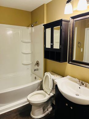 Jonesboro house for rent - A white toilet sits in a bathroom with yellow walls.