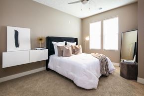 Omaha apartment for rent - A bedroom with a large bed and a ceiling fan.