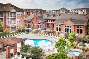 Omaha apartment for rent - A large brick building with a pool in the middle of it.